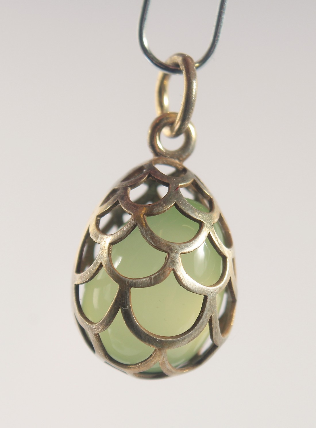 A SILVER AND JADE EGG SHAPED PENDANT, of cage design. 2cm high - Image 2 of 2