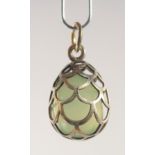 A SILVER AND JADE EGG SHAPED PENDANT, of cage design. 2cm high