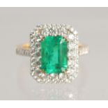 A VERY FINE LARGE EMERALD AND DIAMOND CLUSTER RING, 2.5 carat centre, 18ct gold.