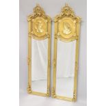 A PAIR OF DECORATIVE GILTWOOD NARROW MIRRORS, the upper sections with moulded female busts. 5ft