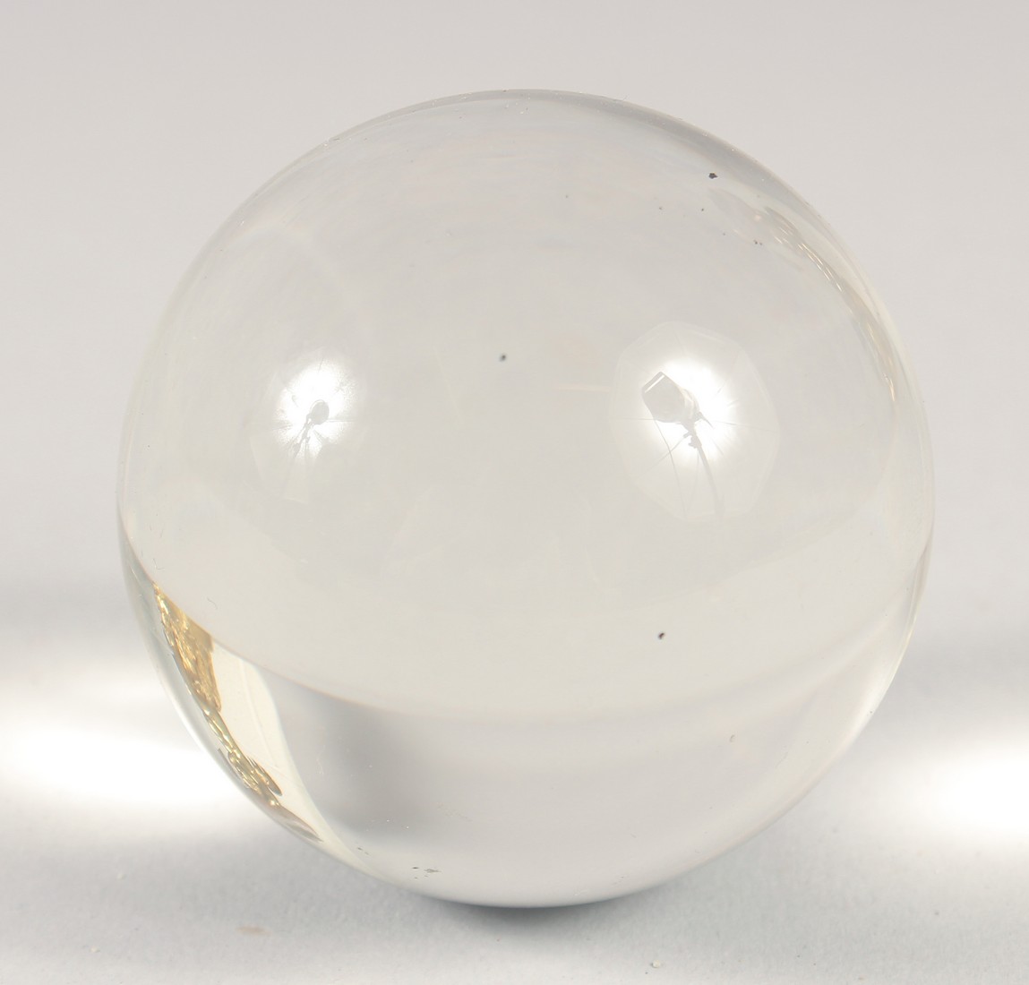 A CRYSTAL BALL on a wooden stand. 2.5ins diameter. - Image 2 of 3