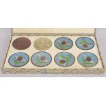 A BOXED SET OF EIGHT JAPANESE DISHES SHOWING THE STAGES OF CLOISONNE PRODUCTION.