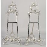 A PAIR OF ORNATE SILVERED EASELS 21ins high
