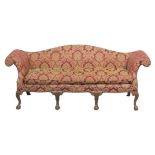A GEORGE III STYLE MAHOGANY FRAMED THREE SEATER HUMP BACK SETTEE with scroll arms on carved cabriole