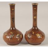 A PAIR OF JAPANESE MIXED METAL INLAID BRONZE VASES, each relief decorated with native flora and