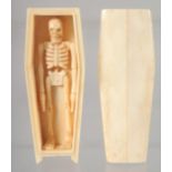 A BONE COFFIN CONTAINING A SKELETON. 11.5cm long