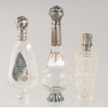 THREE SILVER MOUNTED CUT GLASS SCENT BOTTLES.