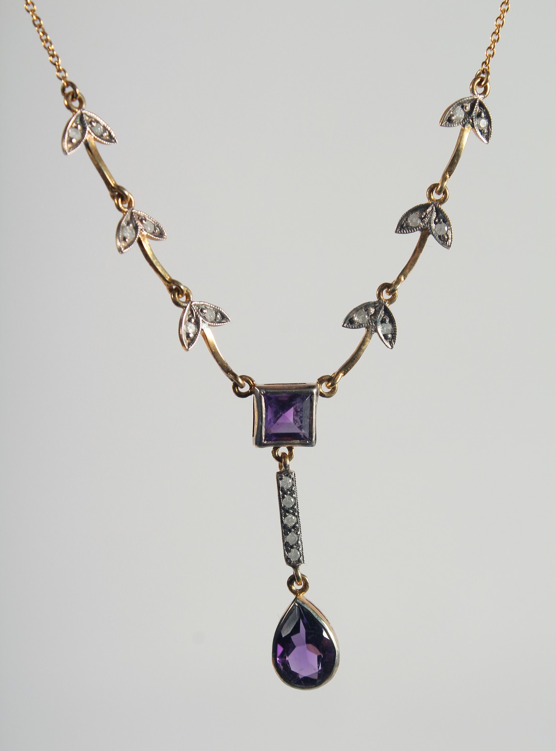 A 9ct. GOLD AND SILVER AMETHYST AND DIAMOND NECKLACE.