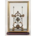 A GOOD BRASS "GRASSHOPPER" SKELETON CLOCK, in a glass case with a wooden stand 19.5ins high.