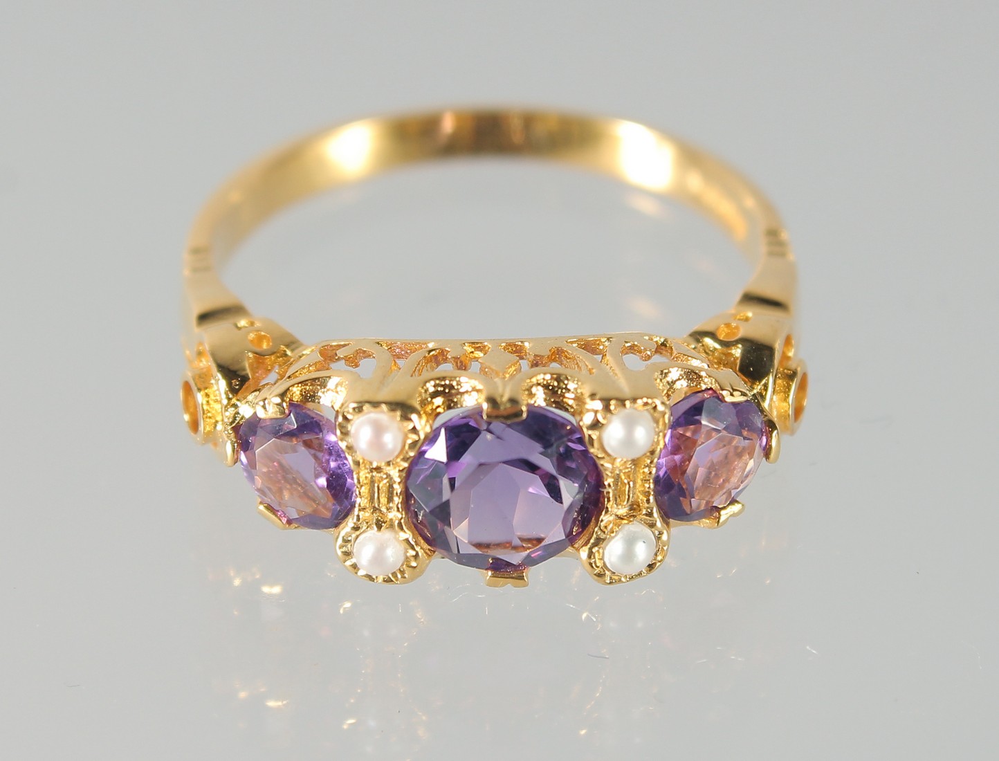 A SILVER AND GOLD-PLATED AMETHYST AND PEARL RING.