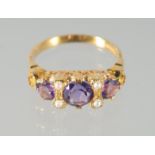 A SILVER AND GOLD-PLATED AMETHYST AND PEARL RING.