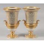 A PAIR OF 19TH CENTURY GILDED TWO HANDLE URN SHAPED VASES. 7ins high.