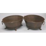 A PAIR OF OVAL METAL PLANTERS with ring handles and paw feet. 29ins wide.