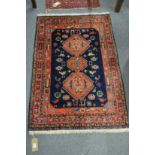 A PERSIAN DESIGN RUG, red and blue ground with stylised animal and bird motifs. 4' 0" x 3' 0"