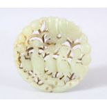 A CHINESE CARVED JADE DISK / PENDANT - Carved with birds aside foliage. 6.5cm.
