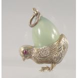 A SILVER AND JADE PENDANT, modelled as a chick carrying an egg on its back. 3cm high