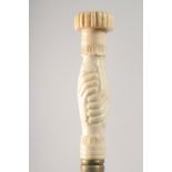 A WALKING STICK WITH CARVED BONE HANDLE as clasped hands.