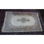 AN INDIAN CARPET, cream ground with floral decoration. 9'3" x 5'10"