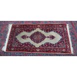 A SMALL INDIAN RUG, crream ground with floral decoration. 4'4" x 2'3"