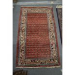 A SMALL PERSIAN RUG, red ground with stylised Boteh decoration. 4'2" x 2'4"