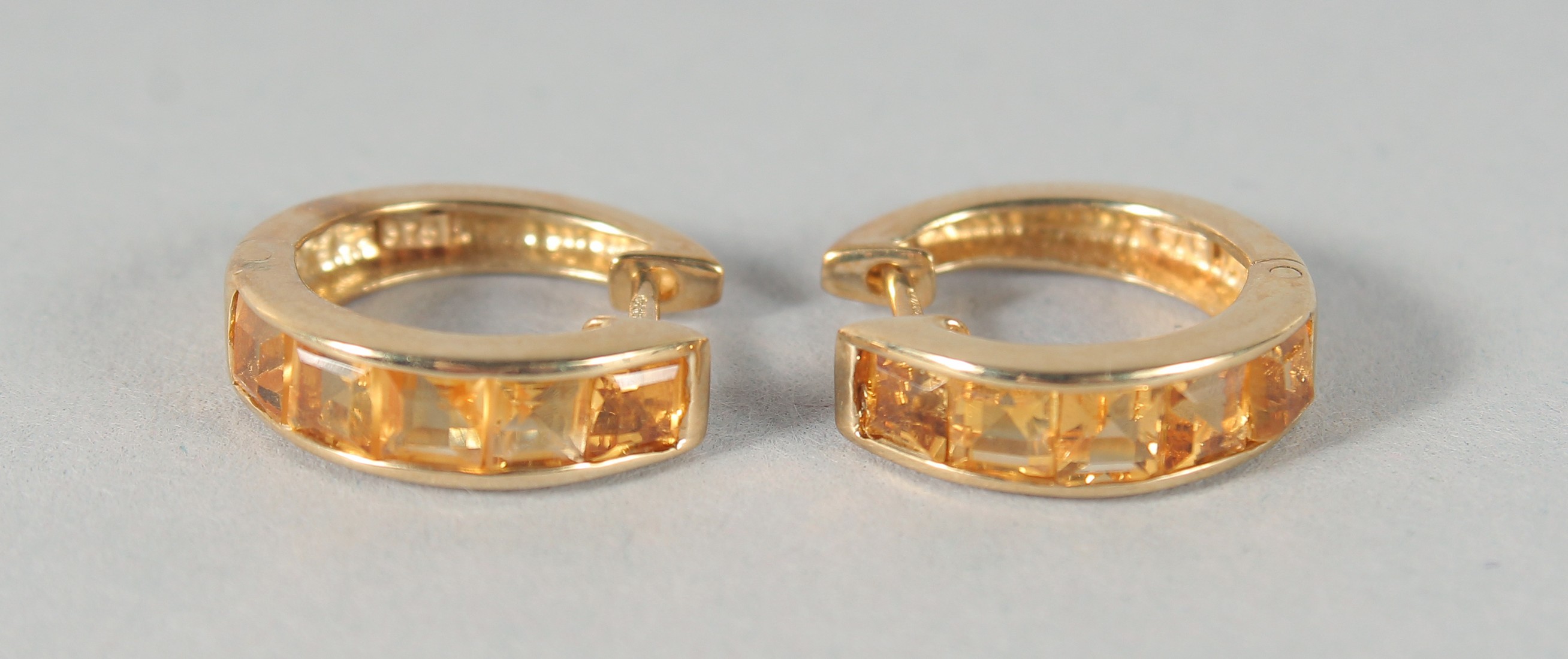 A PAIR OF 9ct. GOLD SQUARE CUT CITRINE HOOP EARRINGS.