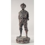 A CAST BRONZE FIGURE OF A BOY WHISTLING, his hands in his pockets, stood on a rock. 29ins high.