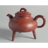 A CHINESE YIXING TEAPOT on tripod legs, with marks to inner lid and base, 13cm high.