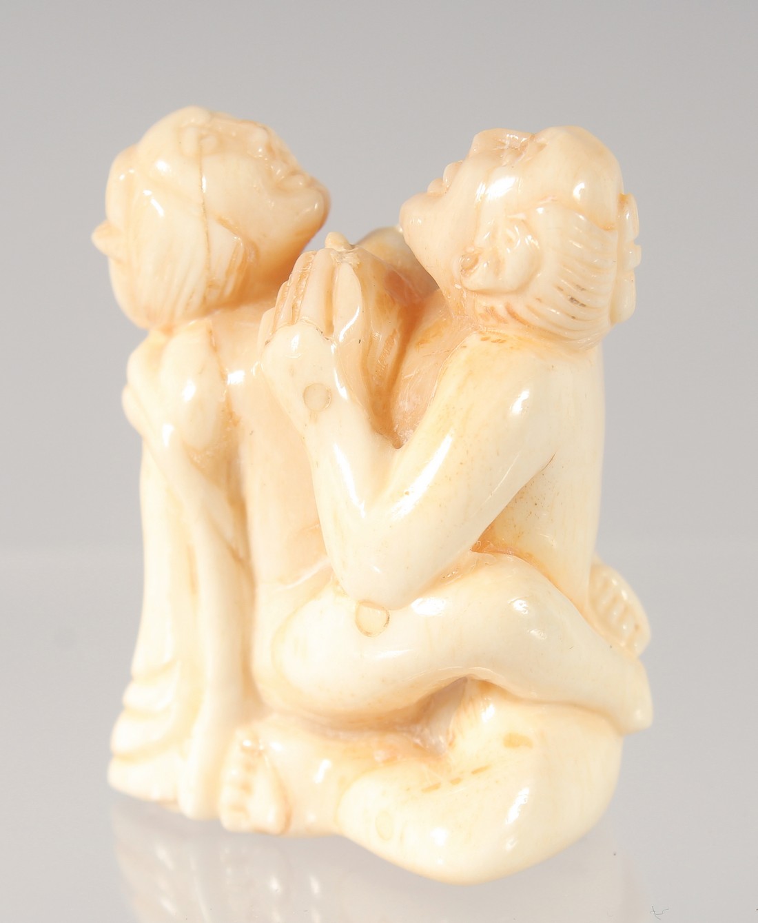 A CHINESE CARVED BONE EROTIC NETSUKE. 4.5cm.