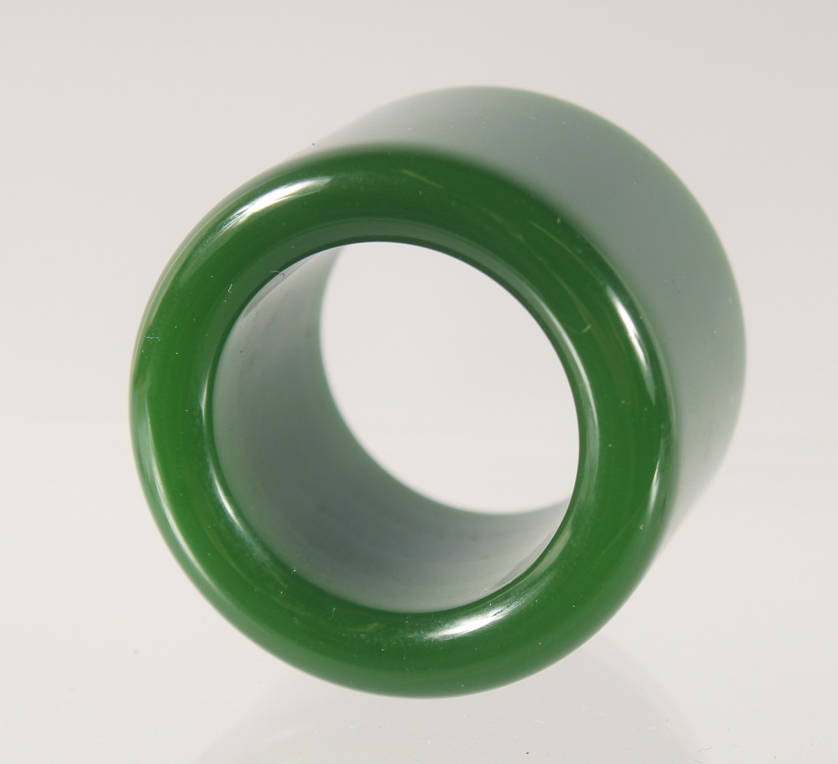 A DARK GREEN JADE ARCHERS RING. 3.5cm diameter.