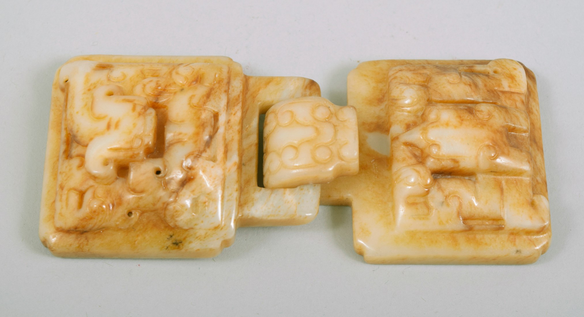 A CHINESE CARVED JADE BUCKLE, with two locking pieces (2).