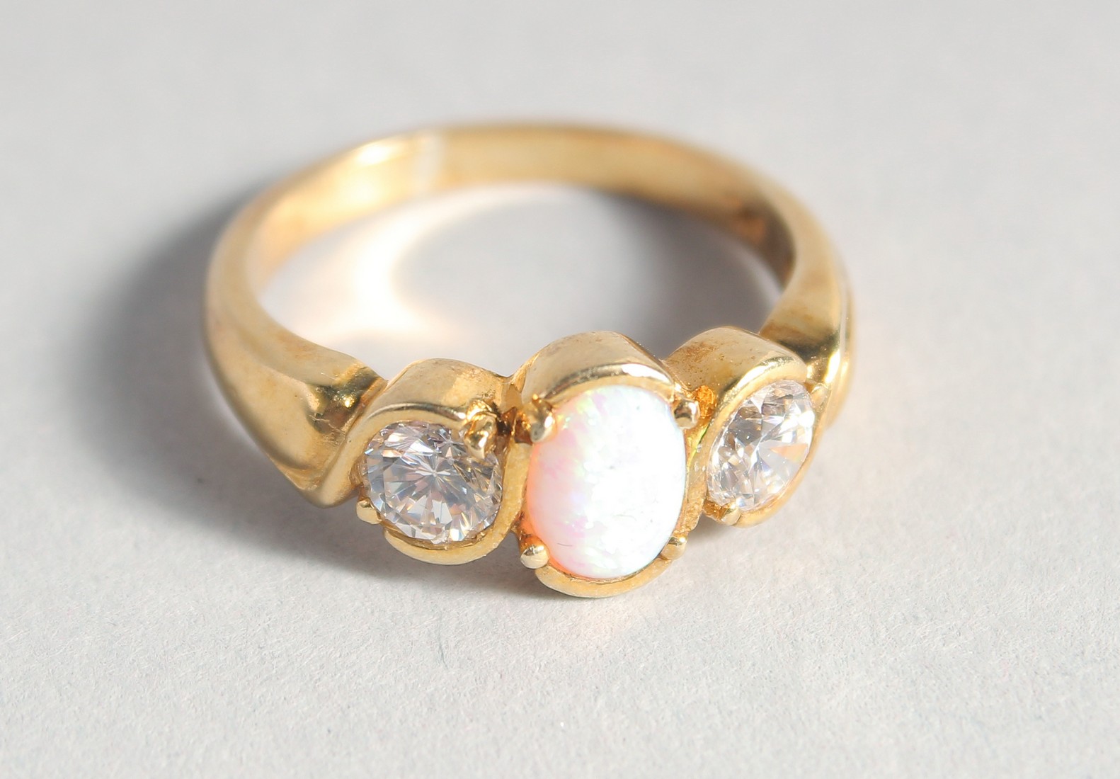 A SILVER 18ct. GOLD-PLATED OPAL AND CUBIC ZIRCONIA RING.