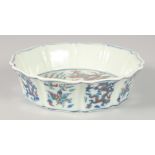 A CHINESE DOUCAI PORCELAIN PETAL FORM BOWL, painted with dragons and phoenix, 17.5cm diameter.