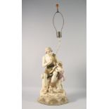 A LARGE ROYAL DUX TABLE LAMP modelled as a man seated on a rock playing a pipe, with a child by