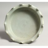 A CHINESE GREEN SHAPED DISH with wavy rim. 9ins diameter.