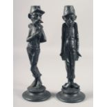 A GOOD PAIR OF 19TH CENTURY FRENCH CARICATURE METAL CANDLESTICKS on circular bases. 13ins high.