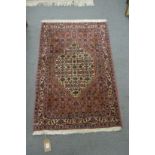 A GOOD SMALL PERSIAN DESIGN RUG, rust ground with stylised floral decoration. 3'5" x 2'3"
