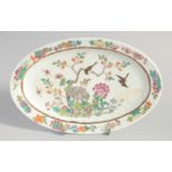 A CHINESE FAMILLE ROSE OVAL PORCELAIN DISH, painted with birds and native flora, six-character