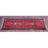 A PERSIAN RUNNER, bright red ground with stylised floral design. 6'8" x 2'2"