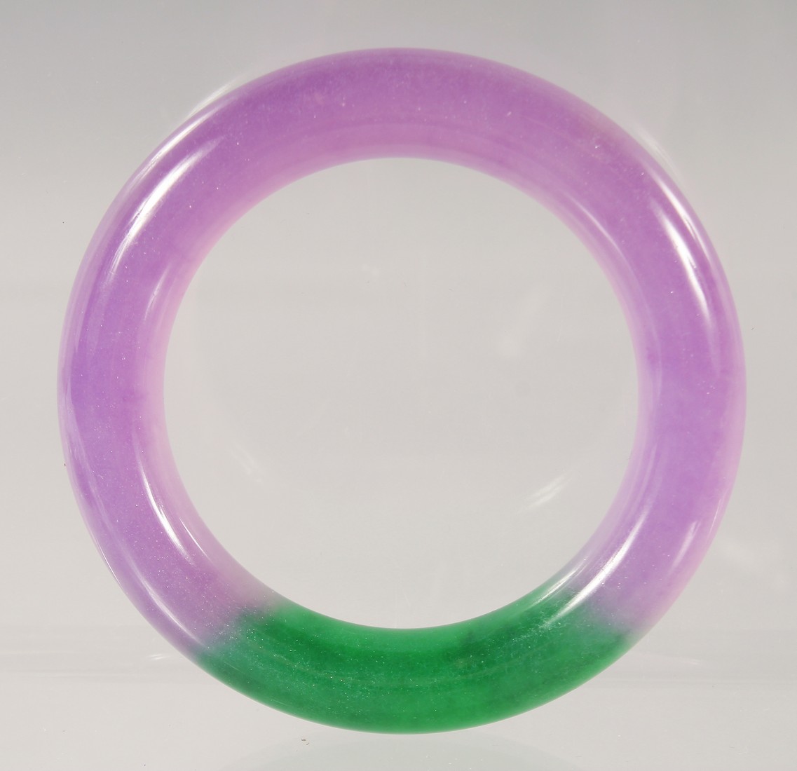 A CHINESE LAVENDER AND GREEN JADE BANGLE 8.5cm diameter.