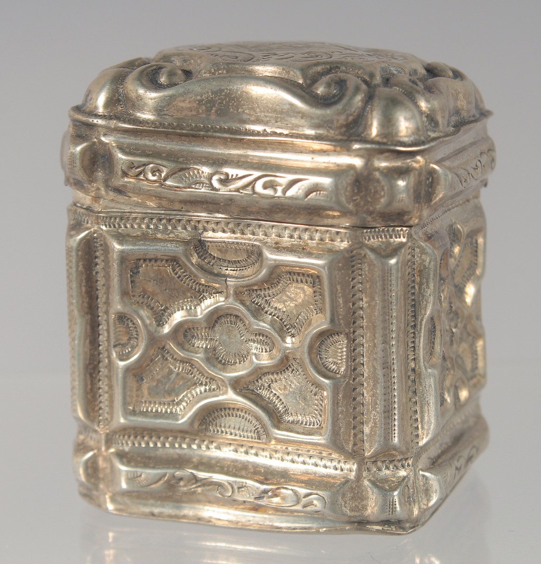 A DUTCH SILVER PILL BOX with embossed decoration. 4.5cm high