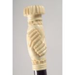 A WALKING STICK WITH CARVED BONE HANDLE modelled as clasped hands.