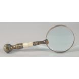 A MAGNIFYING GLASS with brass and mother of pearl handle.