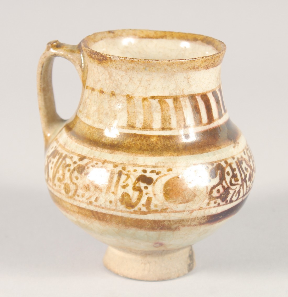 A SMALL KASHAN LUSTRE GLAZE POTTERY EWER, with provenance sticker; Christie's, 9cm high.