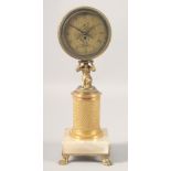 A GILT BRONZE CIRCULAR DESK CLOCK with kneeling figural support on a column, the marble base with