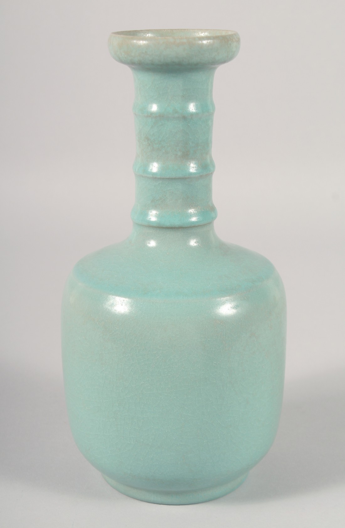 A CHINESE CELADON GLAZE VASE, with ribbed neck, 25.5cm high.