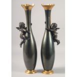 A GOOD PAIR OF 19TH CENTURY BRONZE AND GILT VASES with cupids. 16ins high.