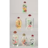 A COLLECTION OF SIX REVERSE-PAINTED SNUFF BOTTLES AND STOPPERS.
