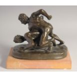 OLIVER TUPTON A BRONZE SCULPTURE, TWO NUDE MALE WRESTLERS. Signed, 9ins long on a marble base.
