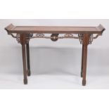 A CHINESE HARDWOOD ALTER TABLE with curving ends and pierced and carved frieze. 5ft long x 1ft