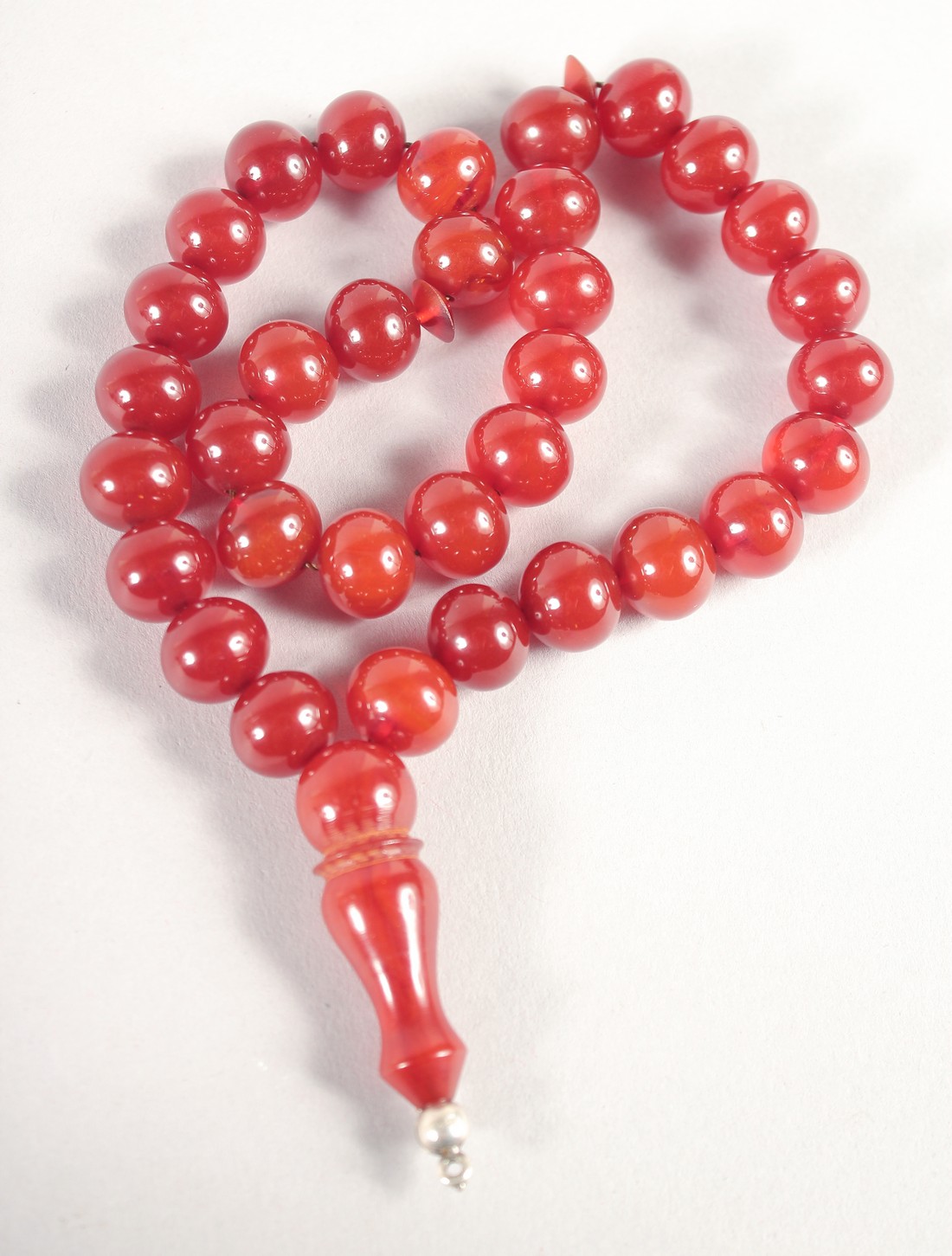 A BAKELITE -POSSIBLY CHERRY AMBER SET OF ISLAMIC PRAYER BEADS.